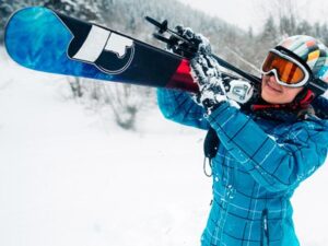 Woman skier carrying skis through the snow at Tamarack Resort in Idaho