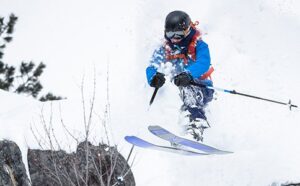 Woman jumping off a rock into powder snow at Tamarack Resort in Idaho