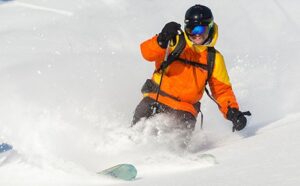 Smiling skier takes big turn in powder at Tamarack Resort in Idaho