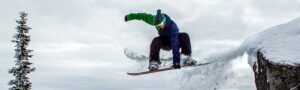 Snowboarder hitting a safety grab off a rock at Tamarack Resort in Idaho