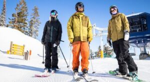 Three skiers hanging outside of Wildwood Lift at Tamarack Resort in Idaho