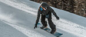 Snowboarder making a big turn on the slopes at Tamarack Resort in Idaho.